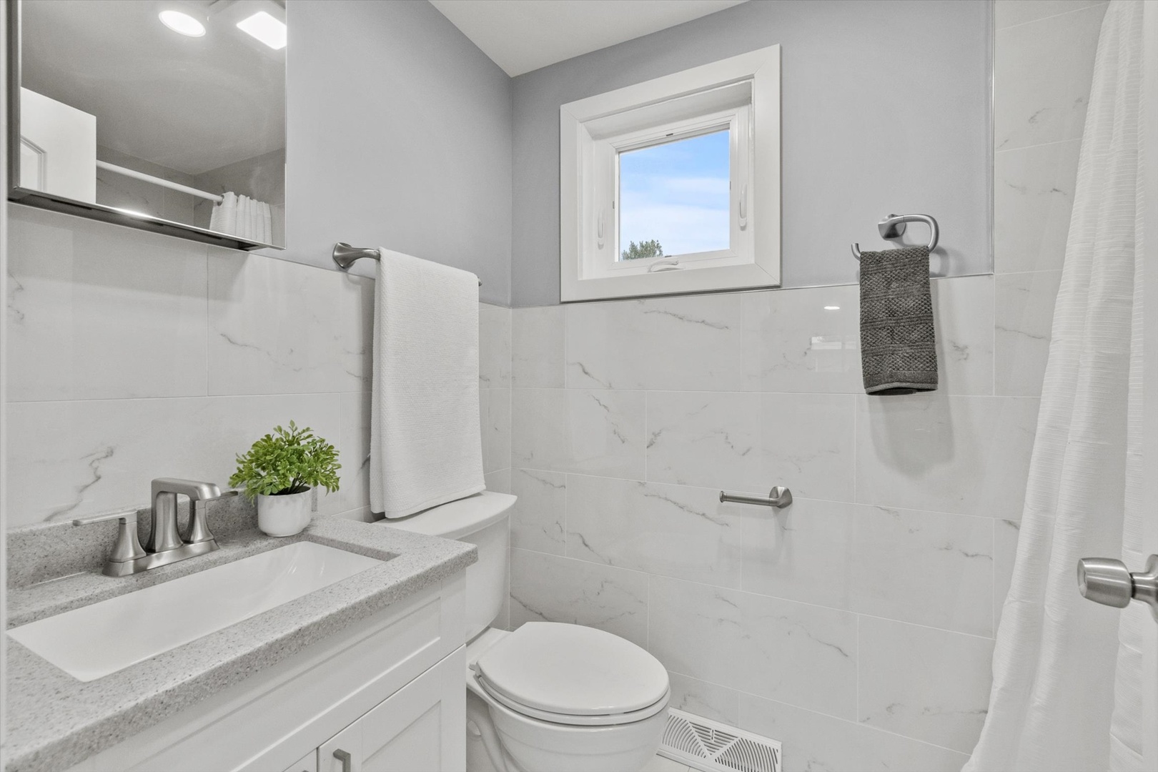 7249 North Campbell Avenue, Unit B Chicago, IL 60645 - Photo 10 of 27 a bathroom with a sink mirror vanity and toilet