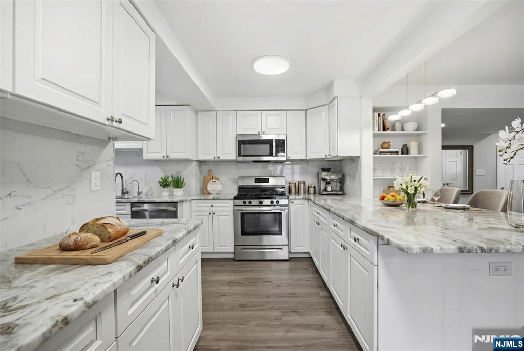 53 Forest Road Demarest, NJ 07627 - Photo 4 of 17 a kitchen with stainless steel appliances granite countertop a stove sink and cabinets