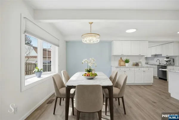 a dining room with furniture a chandelier and wooden floor