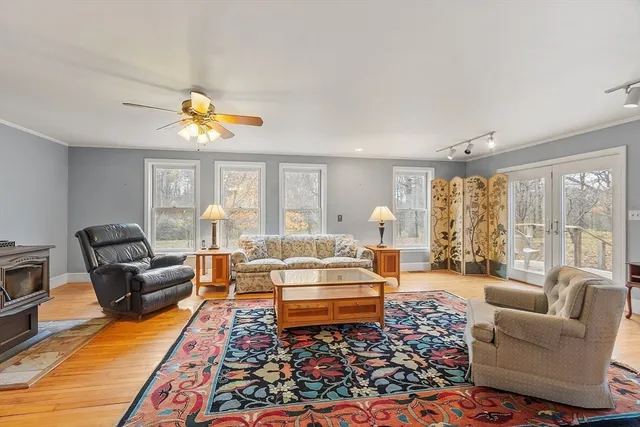 a living room with furniture a rug and a floor to ceiling window