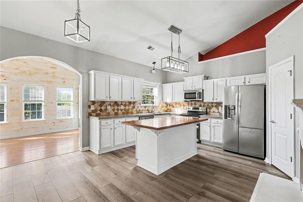 19 Safe Harbor Trail Dallas, GA 30157 - Photo 4 of 28 a kitchen with stainless steel appliances granite countertop a refrigerator a sink dishwasher a stove and white cabinets with wooden floor