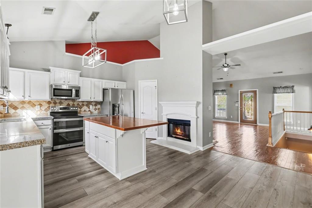19 Safe Harbor Trail Dallas, GA 30157 - Photo 6 of 28 a kitchen with stainless steel appliances granite countertop a wooden floors and white cabinets