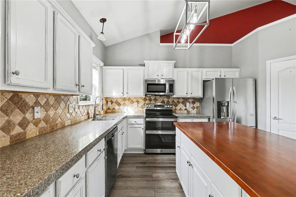 19 Safe Harbor Trail Dallas, GA 30157 - Photo 7 of 28 a kitchen with kitchen island granite countertop a sink a counter top space stainless steel appliances and cabinets