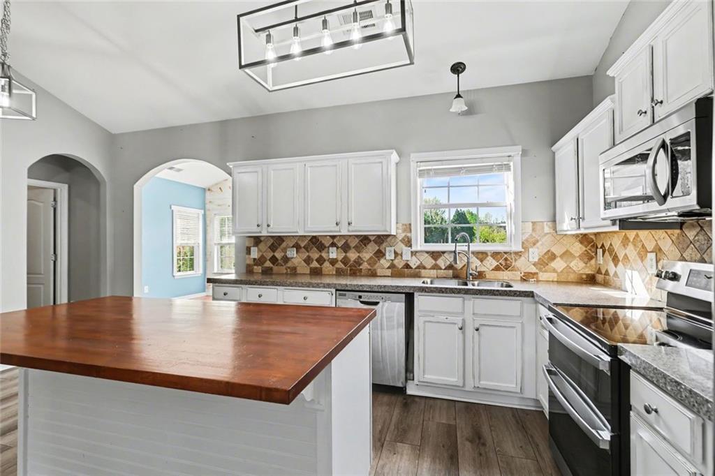 19 Safe Harbor Trail Dallas, GA 30157 - Photo 8 of 28 a kitchen with stainless steel appliances granite countertop a sink a stove cabinets counter space and a window
