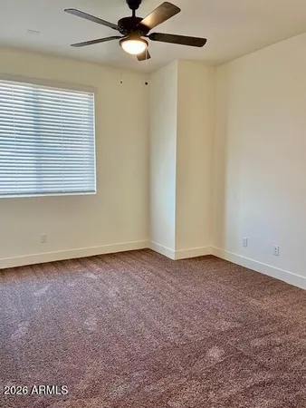 an empty room with a window and a fan
