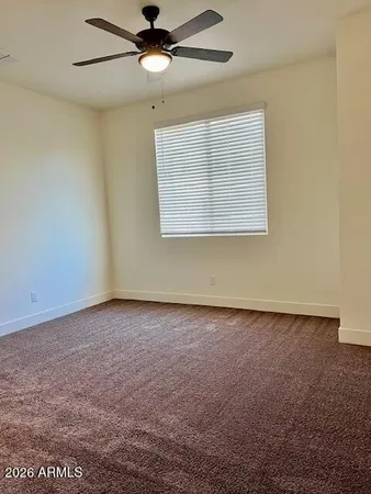 an empty room with a window and a ceiling fan