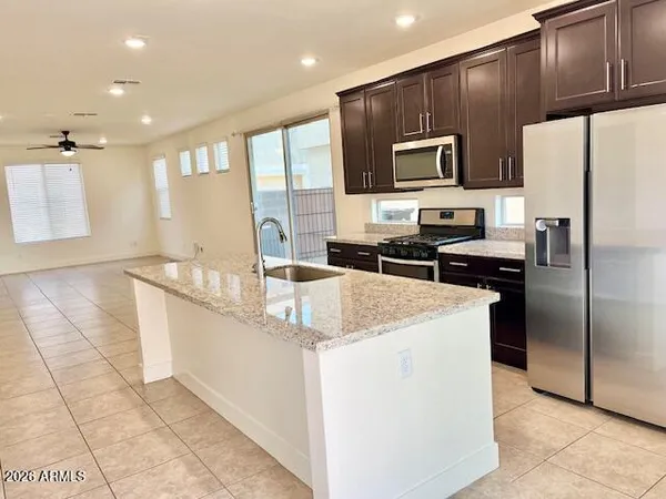 a kitchen with stainless steel appliances a sink a stove a microwave a sink a refrigerator and cabinets