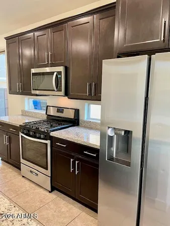 a kitchen with granite countertop stainless steel appliances and wooden cabinets