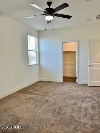 an empty room with windows and fan