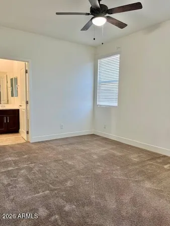 an empty room with a ceiling fan and a window