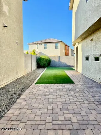 a view of a backyard with plants and large tree