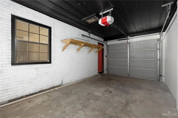 a view of an empty room with a ceiling fan and window