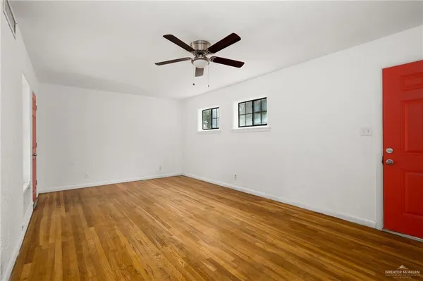 a view of empty room with wooden floor