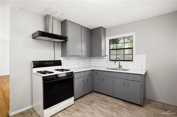 a kitchen with stainless steel appliances a sink a stove and cabinets