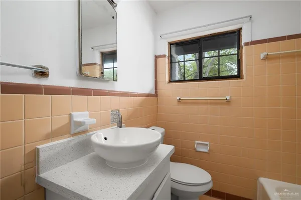 a bathroom with a toilet a sink and mirror