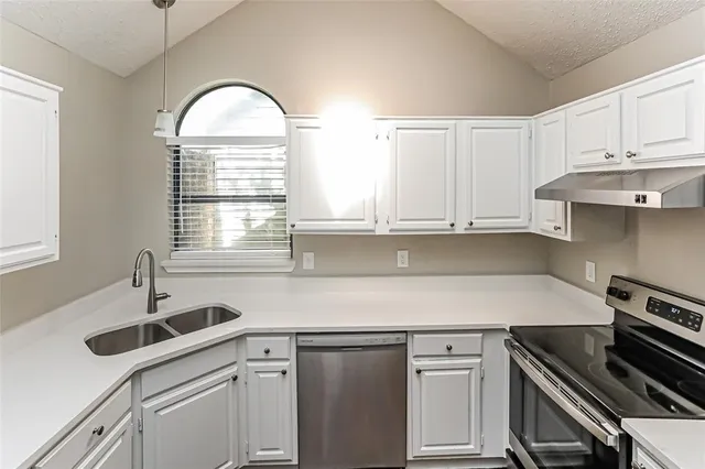 a kitchen with a sink stove and cabinets