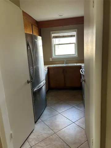 a room with a wooden cabinets and refrigerator