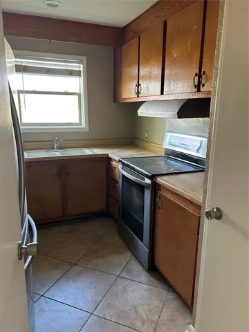 a kitchen with a sink a stove and cabinets
