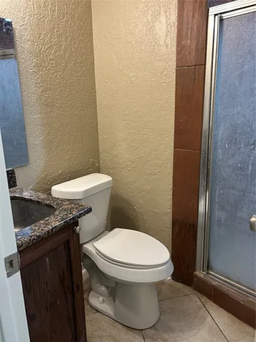 a white toilet sitting next to a shower