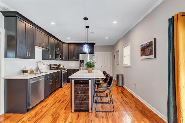 a kitchen with stainless steel appliances granite countertop a sink a stove a refrigerator cabinets and living room view