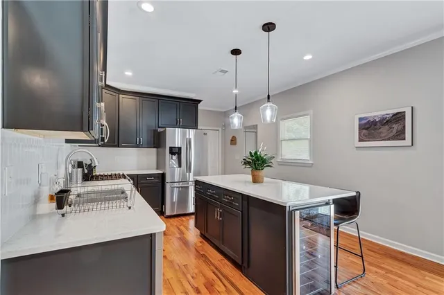 a kitchen with a sink a counter top space stainless steel appliances and cabinets