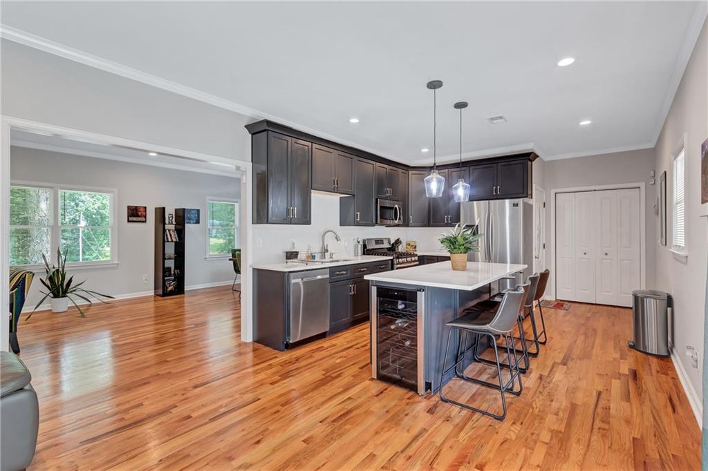 2418 Bolling Brook Drive Southwest Atlanta, GA 30311 - Photo 14 of 37 a kitchen with stainless steel appliances a dining table chairs stove and refrigerator