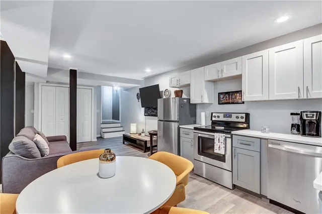 a kitchen with stainless steel appliances granite countertop a sink a stove and refrigerator