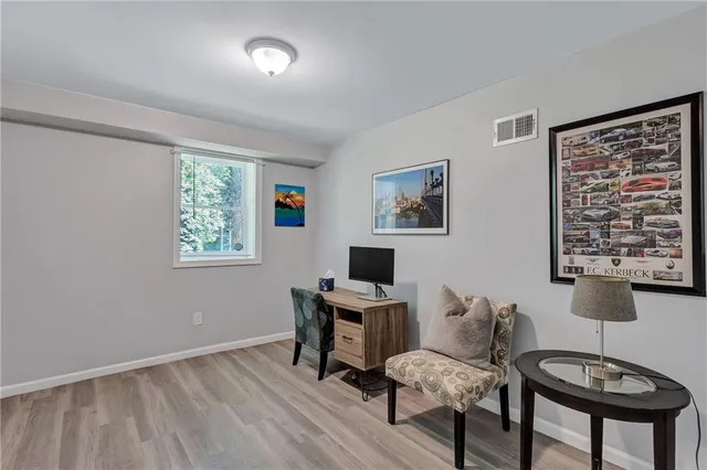 a view of a workspace with furniture and a window