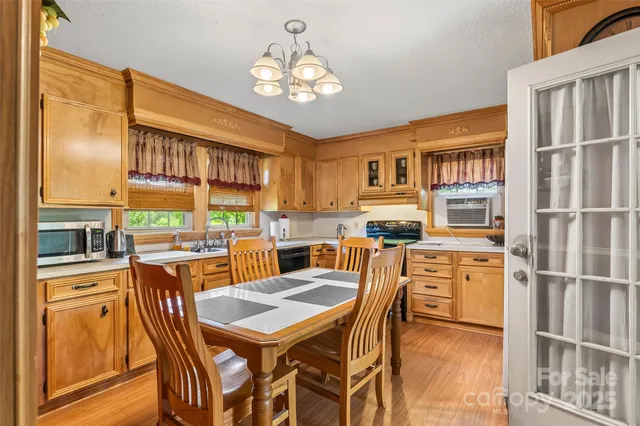 a view of a dining room with furniture a chandelier and wooden floor