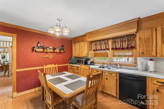 a view of a dining room with furniture a chandelier and wooden floor