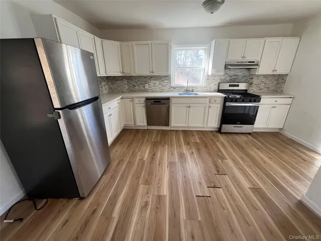 a kitchen with white cabinets and white appliances