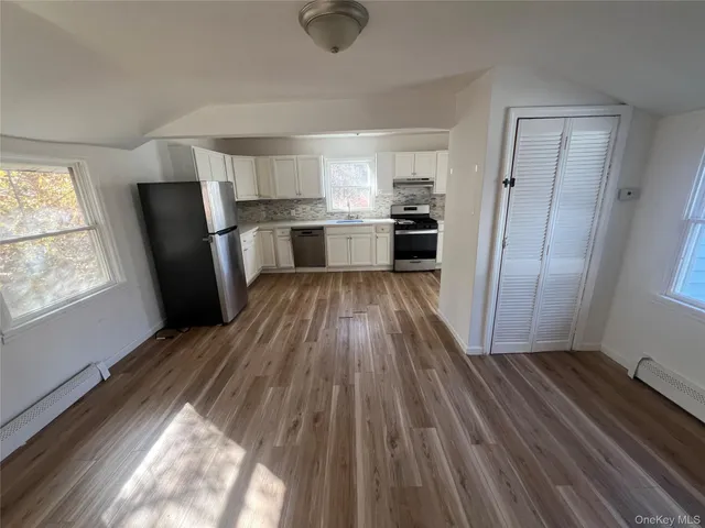 a kitchen with wooden floors and refrigerator