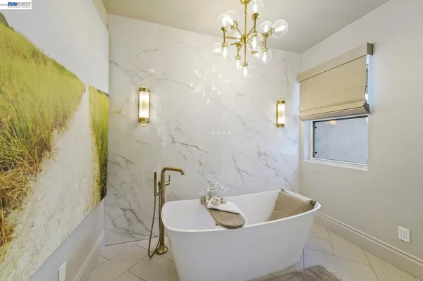 a spacious bathroom with a granite countertop sink a mirror and next to a window