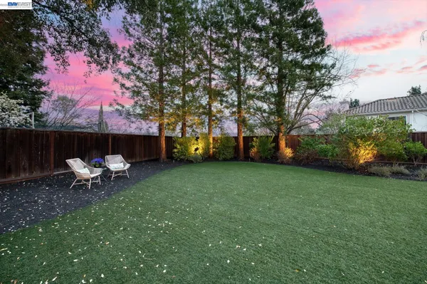 a view of a patio with couches chairs and a table and chairs with wooden fence