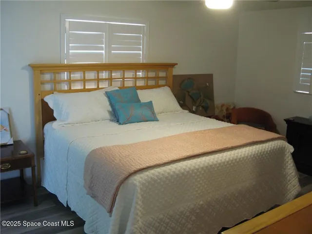 a large bed sitting in a bedroom next to a window