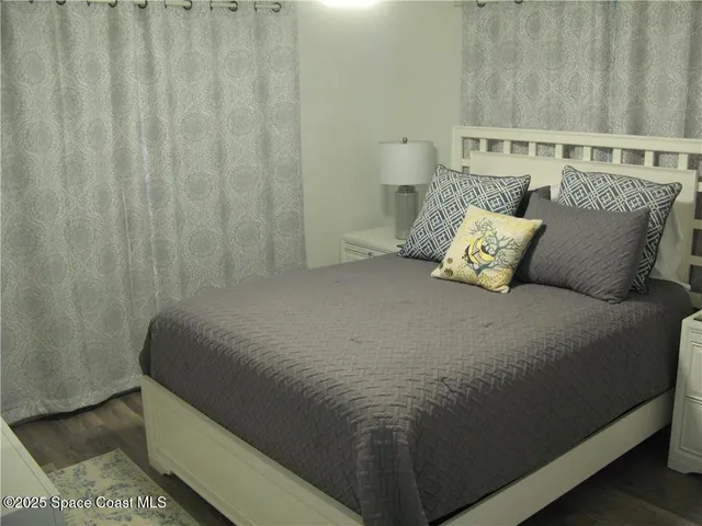 a bed sitting in a bedroom next to a shower curtain