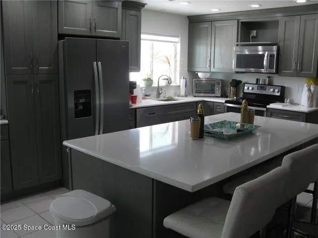 a kitchen with stainless steel appliances a sink a table and chairs