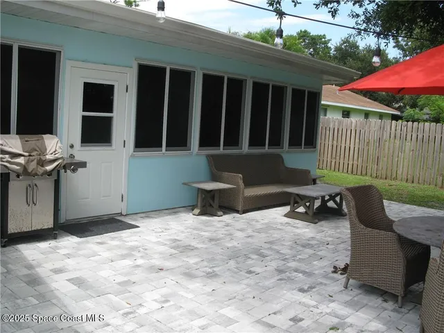 a view of a chair and tables in the back yard of the house