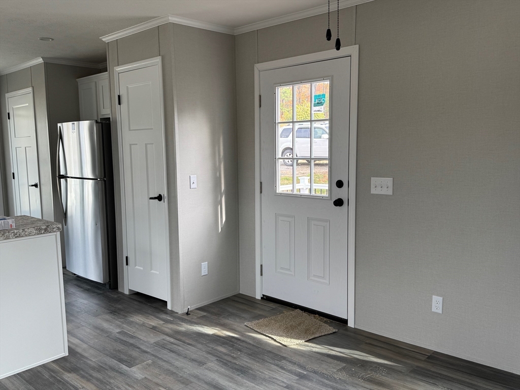 602 Fitchburg Road, Unit 19 Greenville, NH 03048 - Photo 5 of 14 a view of an empty room with wooden floor and a window