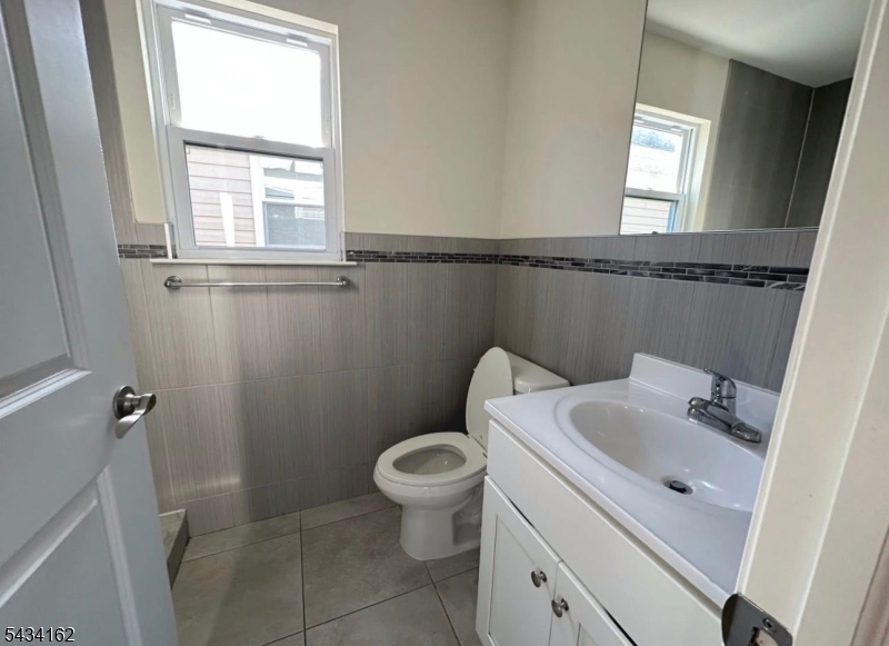 25 Amity Street, Unit 2 Elizabeth, NJ 07202 - Photo 3 of 3 a bathroom with a sink a toilet and a mirror