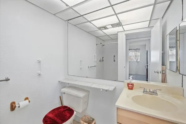 a bathroom with a sink vanity mirror and toilet