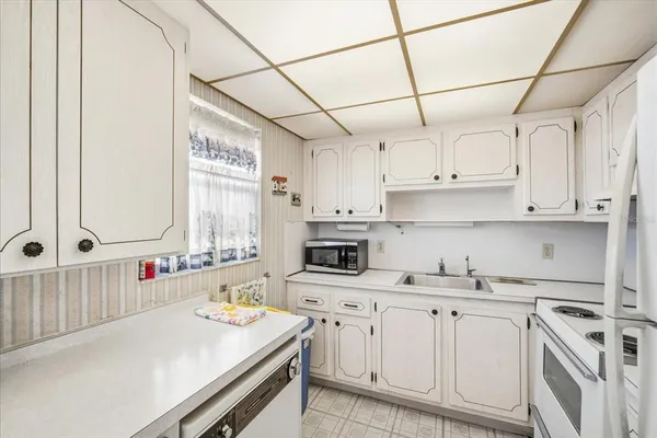 a kitchen with white cabinets and white appliances