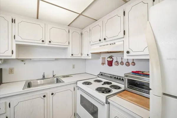 a kitchen with white cabinets and white appliances
