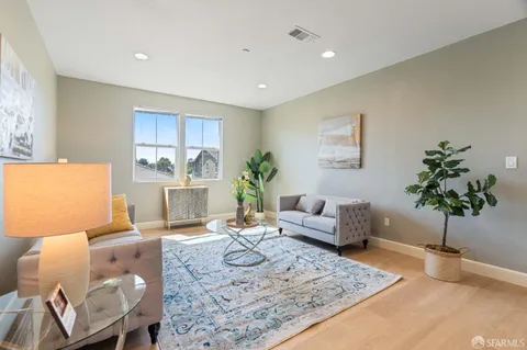 a living room with furniture and a potted plant