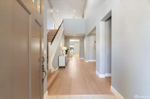 a view of a hallway with wooden floor and staircase