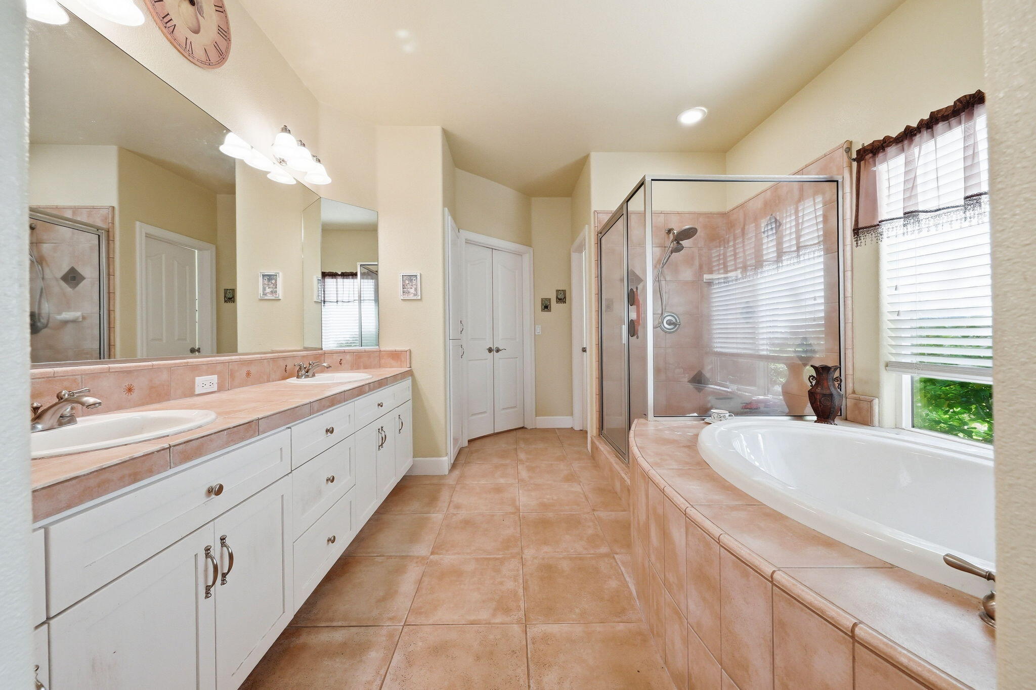2175 Tradition Way Redding, CA 96001 - Photo 16 of 36 a spacious bathroom with a double vanity sink a large mirror a shower and bathtub