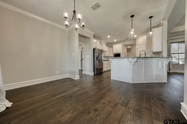 a view of a kitchen with cabinets and wooden floor