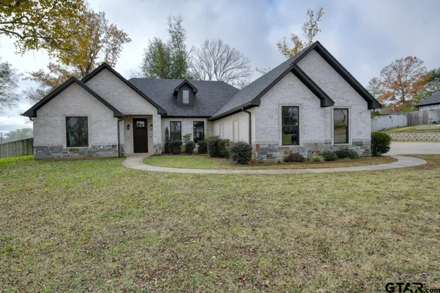 a view of a house with yard and a large tree center