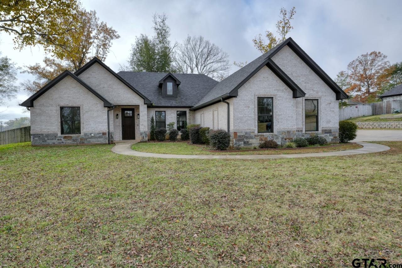 a view of a house with yard and a large tree center