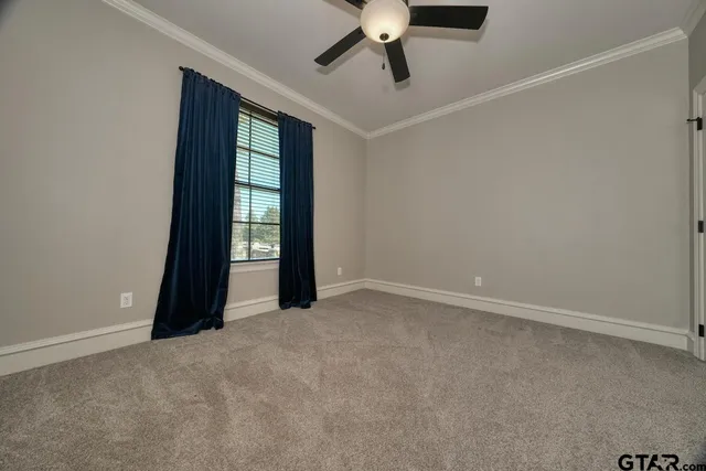 an empty room with a ceiling fan and window